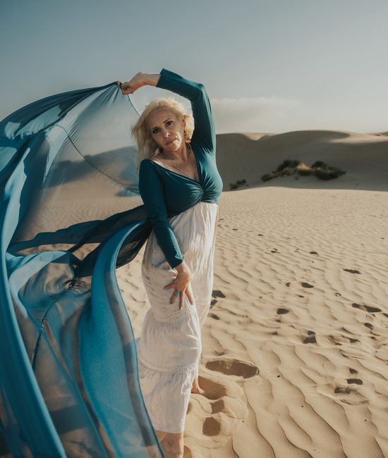 woman in a blue flowy dress in the sand dunes