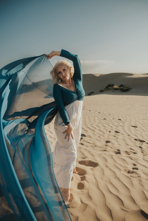 woman in a blue flowy dress in the sand dunes