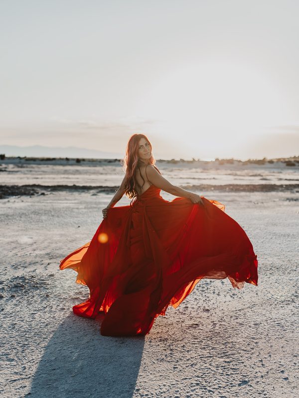 Woman in a red dress walking on the salt flats at the Great Salt Lake