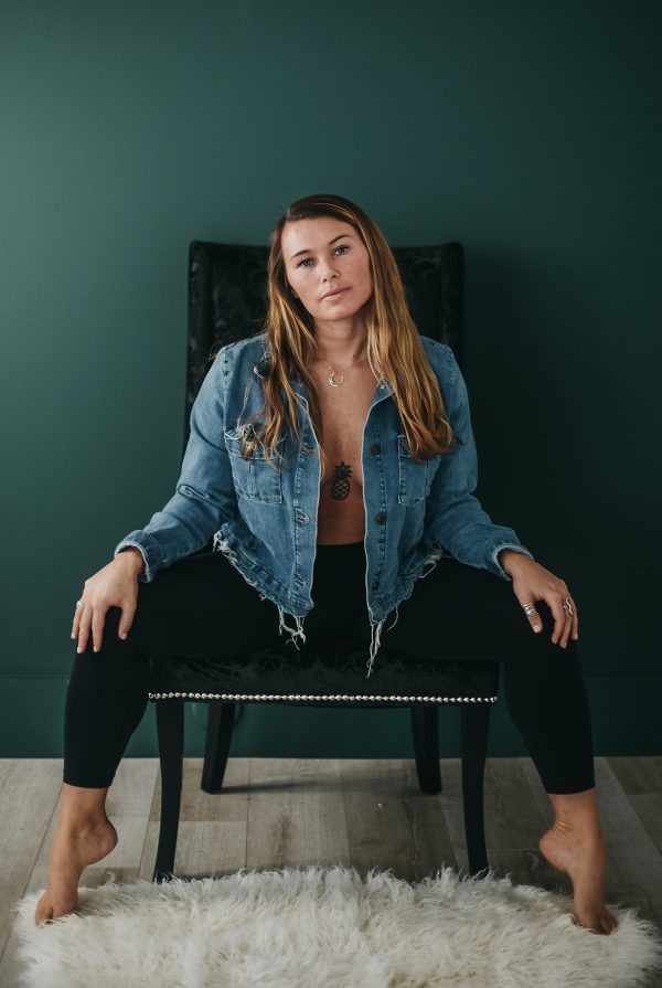Woman in a studio sitting on a chair with her hands on her knees
