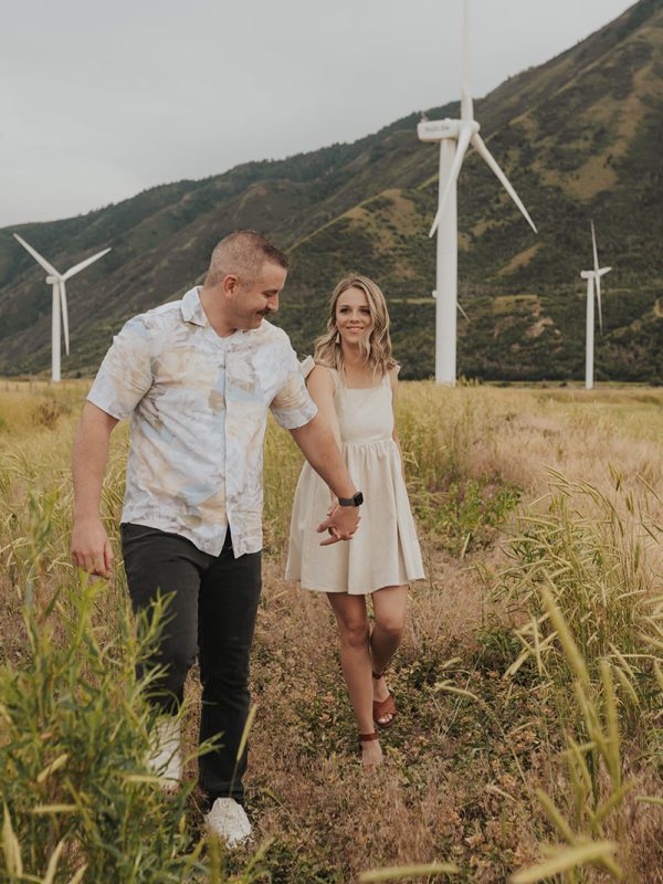 a couple gazing into each others eyes in a windmill farm