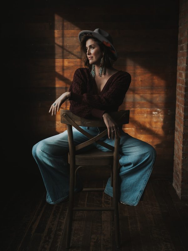Woman in a room looking out a window branding photoshoot