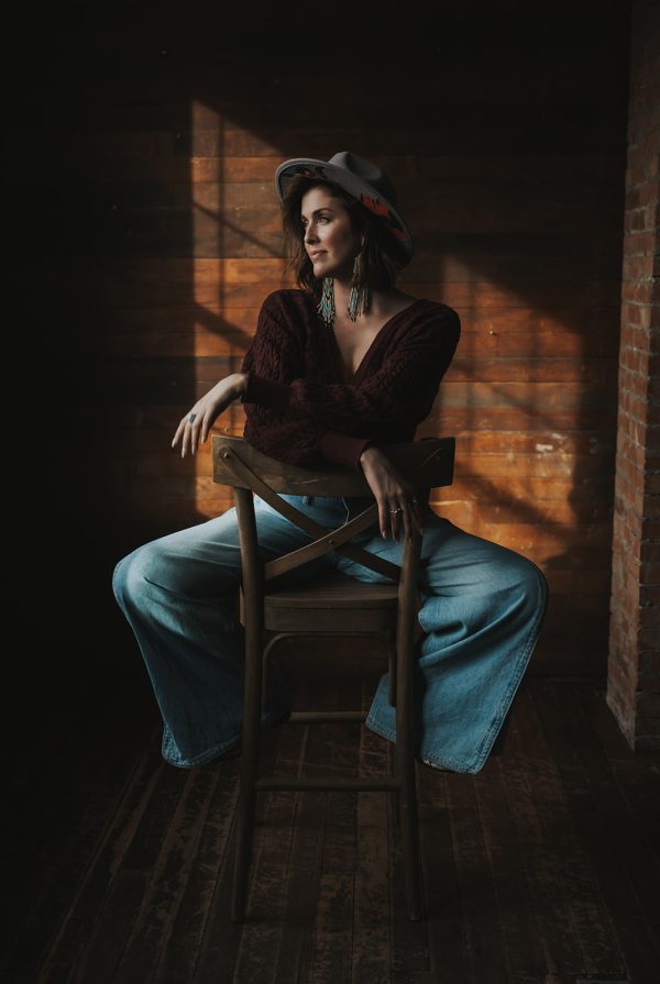 Woman in a room looking out a window branding photoshoot