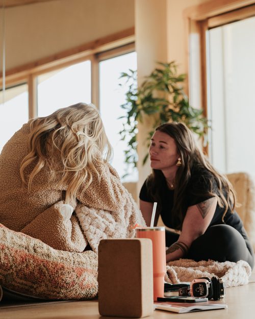 Retreat facilitator providing emotional support during a guided healing exercise at a transformational women's retreat in Utah.